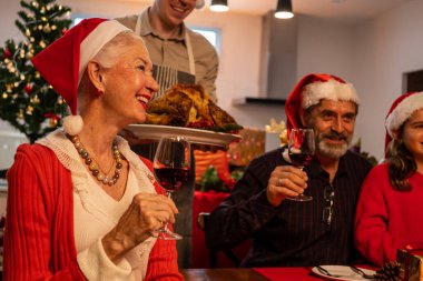 Christmas dinner party with roasted turkey, Happy family enjoying with Christmas celebration eating food together at home, Christmas celebration concept
