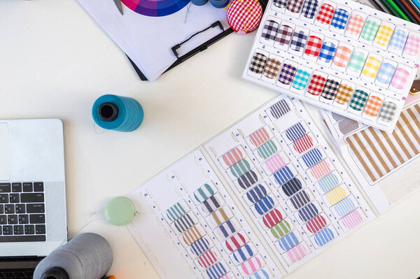 Sewing machine and accessories on table at dressmaking workshop, Dressmaker working in workshop, Tailor fashion designer checking measurements and fitting of dress, Small business owner