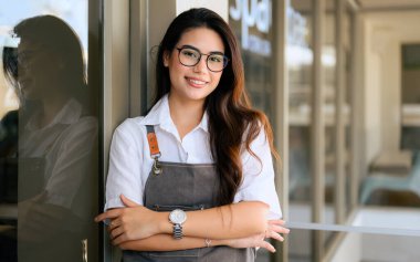 Smiling portrait of young barista business owner at retail coffee shop, People opening shop, High quality photo