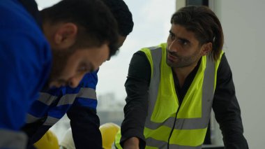 Proje planının planını kullanan profesyonel inşaat mühendisleri. İnşaat, mimarlık ve inşaat konseptinde beyin fırtınası yapıyor ve birlikte çalışıyorlar.
