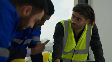 Proje planının planını kullanan profesyonel inşaat mühendisleri. İnşaat, mimarlık ve inşaat konseptinde beyin fırtınası yapıyor ve birlikte çalışıyorlar.