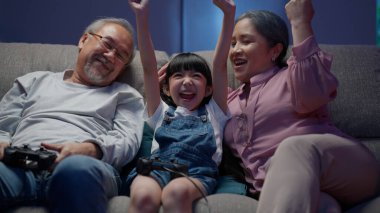 Mutlu kız büyük anne ve büyük babasıyla video oyunu oynuyor, sağlıklı büyükbaba ve büyükannesi evde vakit geçiriyor, son sınıfların aileleriyle aktiviteleri oluyor.