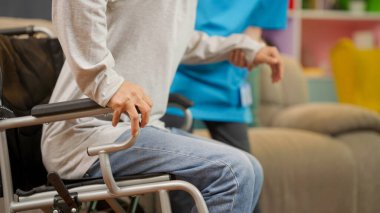 Diz problemleri olan yaşlı bir adam, tekerlekli sandalyede ayakta durmaya çalışan yaşlı bir hasta evde bakıcı hemşireyle egzersiz yapmaya çalışan genç bir fizyoterapist, egzersiz yapması için yaşlı bir adamla ilgilenen ve ona destek olan yaşlı bir adam.