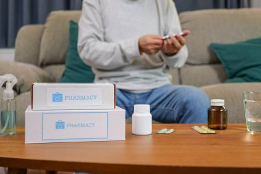 Young doctor examining senior patient at home visit, Senior man consulting medicine with pharmacist, Caregiver nurse taking care of elderly grandfather sitting on sofa at home, Medical service concept