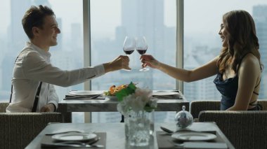 Şehir manzaralı lüks bir binada lüks bir akşam yemeği, şehir silueti olan yüksek binalarda mutlu bir çift yemeği, mutlu yıldönümü yemeği.