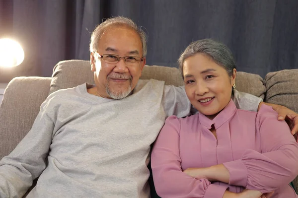 stock image Senior couple setting on sofa. Portrait Senior couple smile to camera, front view.