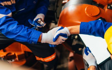 Professional maintenance worker working with machine robotic arms at industrial factory, Technician engineer checking safety of machine and maintenance robotic arms