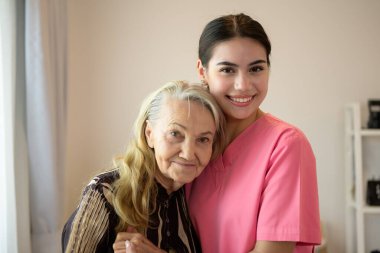 Mutlu bakıcı ve kıdemli hasta gülümseyen ve kameraya bakan yaşlı kadın ve doktor, ev sağlığı ziyareti, evde bakım ve hemşirelik konsepti