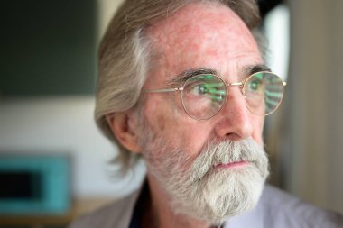 Portrait of healthy senior man with red cup of tea, Retirement man resting and relaxing at home