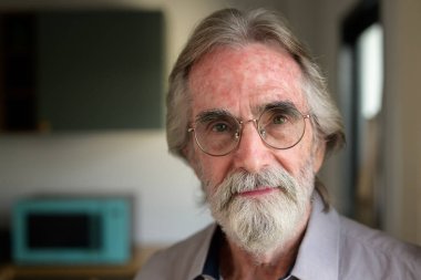 Portrait of healthy senior man with red cup of tea, Retirement man resting and relaxing at home