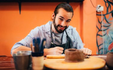 Professional craftsman potter making jug of clay on the potters wheel circle in workshop, Traditional handicraft working, Creativity and art of pottery