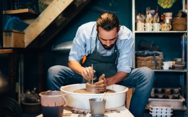 Professional craftsman potter making jug of clay on the potters wheel circle in workshop, Traditional handicraft working, Creativity and art of pottery