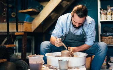 Professional craftsman potter making jug of clay on the potters wheel circle in workshop, Traditional handicraft working, Creativity and art of pottery