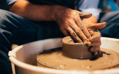 Professional craftsman potter making jug of clay on the potters wheel circle in workshop, Traditional handicraft working, Creativity and art of pottery
