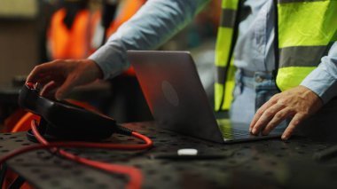 Robot kontrolörünü programlamak, fabrika endüstrisinde robotik silahları programlamak, üretim hattında robotik silahları programlamak, fabrikada dizüstü bilgisayar kontrol makinesi kullanan mühendis robotu kodlamak,