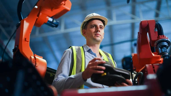 Professional male industrial engineer manager with safety uniform protection white hard hat and yellow vast working in the factory, Engineer foreman controlling machine in the industrial manufacturing
