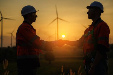 Rüzgâr türbini alanında ekip çalışması yapan profesyonel mühendis, temiz enerji, temiz enerji kaynakları, yeşil ekolojik enerji enerjisi ile çalışan bakım işçisinin silueti görünümü