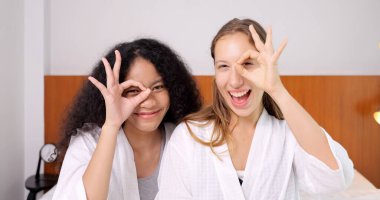 Neşeli yakın arkadaşlar, kameraya olumlu duygular yansıtan kadınlar, kameraya mutluluk içinde poz veren iki kadının kapalı mekan fotoğrafı, insanlar arasında samimi bir aşk.