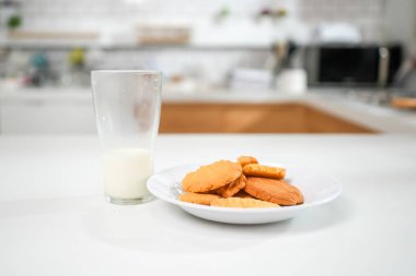 Mutfakta kurabiye ve süt, masada bir bardak süt ve yemek, kurabiye ve sütle kahvaltı. 