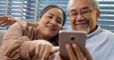 Bir çift mutlu son sınıf öğrencisi gülümseyip evde vakit geçiriyorlar, sevgi dolu sağlıklı yaşlı bir çift, emekliler evde dinleniyor ve dinleniyorlar.