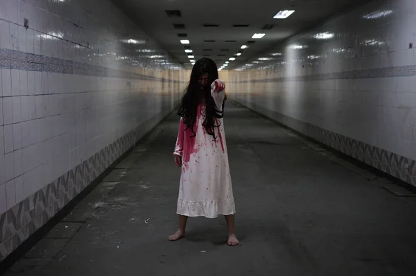 暗闇の中のお化け屋敷の廊下で幽霊のように殺人の後に血痕を持つ白いドレスの恐ろしい女性 ハロウィンの衣装パーティー ホラーシーン — ストック写真