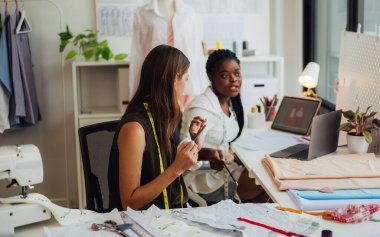 Moda tasarımcısının mutlu çifti atölyede birlikte çalışıyor, kadın terzi ölçümleri ve kıyafet provalarını kontrol ediyor, manken giyim atölyesinde terzilik yapıyor, Small