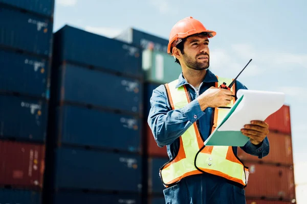 Industrial worker with walkie-talkie checking in cargo freight ship, Warehouse engineer worker working at industrial container yard, Logistics and transportation, Import and export business, High