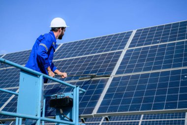 Worker cleaning solar panel at solar cell farm, People working with alternative energy