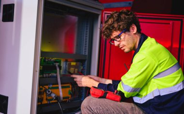 Technician engineer checking and repairing automatic robotic machine at industrial factory, Worker working at production line machine system in factory