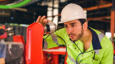 Technician engineer checking and repairing automatic robotic machine at industrial factory, Worker working at production line machine system in factory