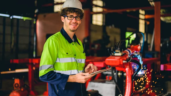 stock image Portrait of happy male mechanical engineer worker in white hard hat and safety uniform standing at manufacturing area holding laptop at industrial factory