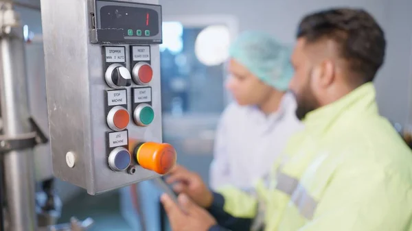Factory worker technician checking and controlling production line at food and beverage factory, Technician managing automatic machine program in food and beverage production line, Business with