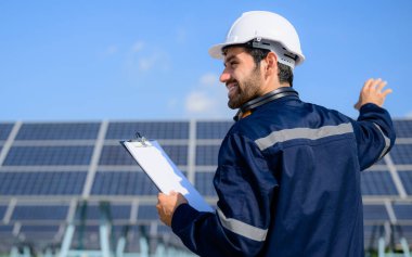 Güneş pili çiftliğine güneş panelleri kuran teknisyen, elektrik santralinde çalışan mühendis, güneş panelleri alanında elektrik sistemi bakımı, çevre dostu ve temiz enerji