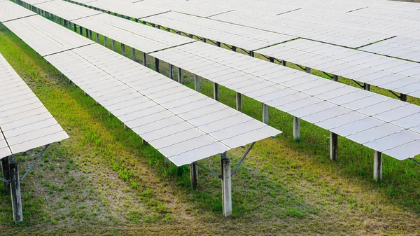 エンジニアの労働者は 太陽電池の農場 緑のフィールドを持つ発電所 生態系の太陽光発電所で働く技術者 クリーンエネルギー技術を持つ人々 再生可能エネルギー — ストック写真