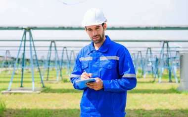 Akıllı erkek mühendis portresi güneş panelleri ile güneş çiftliğinde, mühendis ile güneş çiftliği, güneş hücresini analiz eden işçi, yenilenebilir enerji, yenilenebilir ve sürdürülebilir enerji üretimi