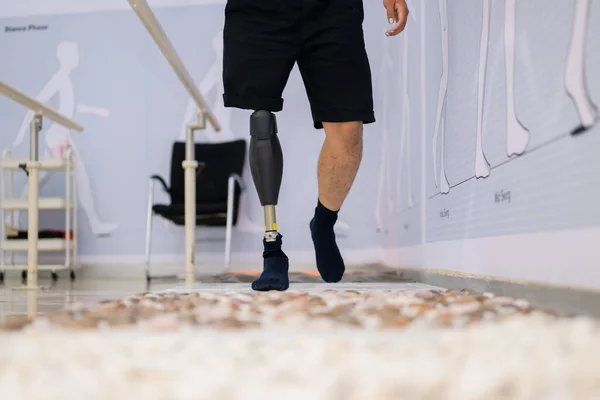 Athlete man with prosthetic leg walking at health care center, People with high tech technology at prosthetic manufacturing, New artificial limb production for disabled people