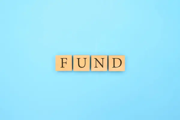 抽象的な青の背景を持つ木製のブロックに書かれたファンドテキスト ファンドの言葉を持つ木製のキューブ 資金調達とビジネスライフ管理の概念 生命保険への投資 — ストック写真