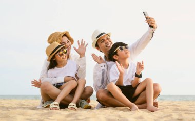 Mutlu bir aile babası, anne kız ve oğlu sahilde birlikte tatil yapıyor, plajda seyahat eden bir aile, tatilde sahilde birlikte seyahat eden mutlu bir Asyalı aile, sahil seyahati yapan bir aile,