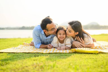 Mutlu bir aile hafta sonu parkta dinleniyor ve dinleniyor, aile babası ve kızı parkta piknik yapıyor, ebeveynler kızlarıyla seyahat ediyor, aile hayatı sürüyor. 