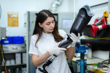 Profesyonel protez teknisyen protez bacağını kontrol ediyor ve kalitesini kontrol ediyor. Laboratuvarda çalışıyor. Protez üretiminde yüksek teknolojili geliştirme uzmanı.