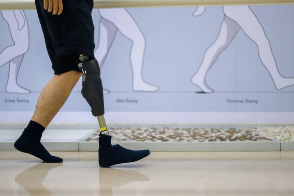 Athlete man with prosthetic leg walking at health care center, People with high tech technology at prosthetic manufacturing, New artificial limb production for disabled people