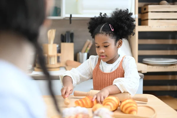 stock image Happy children girls with bread and cookies playing with flour and laugh in kitchen, Little girls making bread in the kitchen, Children standing at cooking counter preparing ingredient for dinner meal