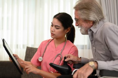 Steteskop hastası olan profesyonel kadın doktor, evde ya da huzurevinde yaşlı bir hastaya bakan doktor ya da hemşire, ev ziyareti sırasında doktor ve yaşlı adam.