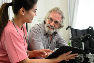 Steteskop hastası olan mutlu kadın doktor, evde ya da huzurevinde yaşlı bir hastaya bakan doktor ya da hemşire, ev ziyareti sırasında doktor ve yaşlı adam.