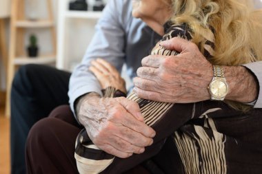 Evde sağlıklı bir yaşam tarzı olan mutlu emekli çift oturma odasındaki kanepede sevgi ve kaynaşma yaşayan mutlu son sınıf çifti gülümseyen birkaç son sınıf öğrencisi dinlenen ve dinlenen insanlar...