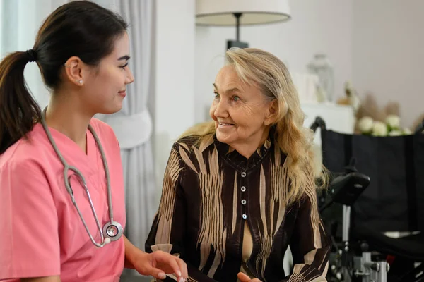 Female doctor talking with elder patient at home visit, People with healthcare, Doctor or nurse caregiver with senior patient at home or nursing home, Professional female doctor with stethoscope
