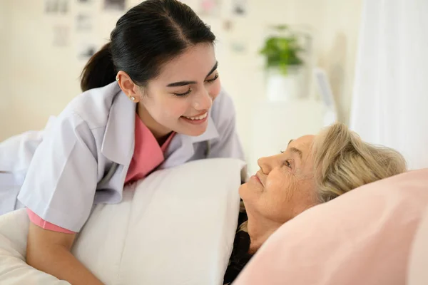 Doctor caregiver and senior woman during home visit, Doctor or nurse caregiver with senior patient at home or nursing home, Professional female doctor with stethoscope visiting patient