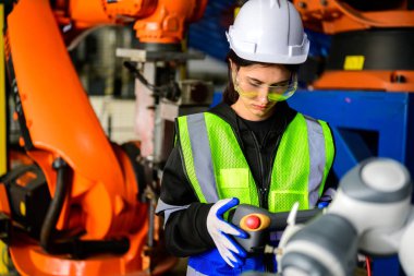Portrait of confident female maintenance technician working with machinery at industrial factory, Technician engineer checking safety of machine and maintenance robotic arms, Industry engineer clipart