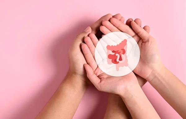 People holding virtual intestine icon on hands with pink background, Health checkup concept, Colon cancer, Bowel inflammatory, Probiotics for stomach, Concept of healthcare and medicine