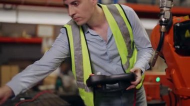 Endüstriyel imalat fabrikasında çalışan güvenlik üniforması koruması olan endüstri mühendisi depoda robot makinelerini kontrol eden ve kontrol eden teknisyen, mühendislik konsepti.
